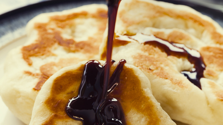 plate of toutons being drizzled with molasses