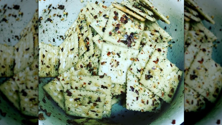 Mixing seasoning into saltine crackers to make Alabama fire crackers