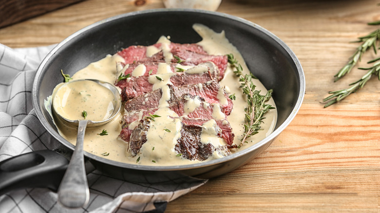 steak diane with sauce in pan