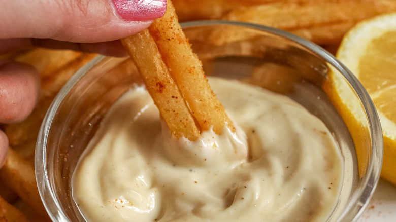 fries being dipped in truffle aioli