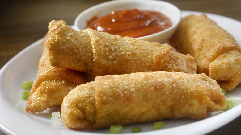 An egg roll platter with a dip.