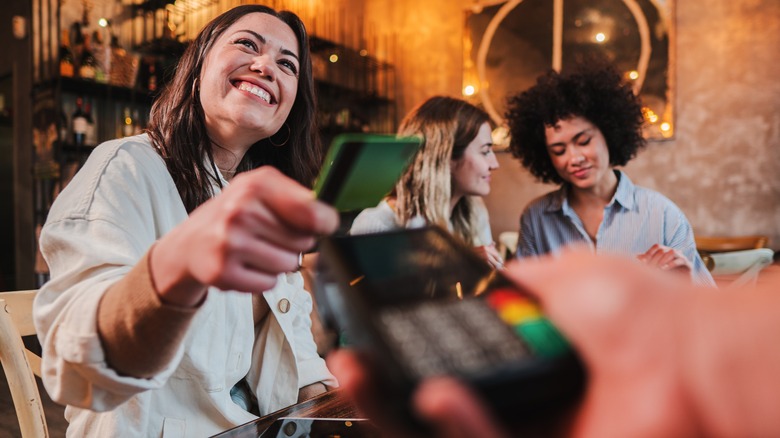 A group of diners paying for a meal with a credit card