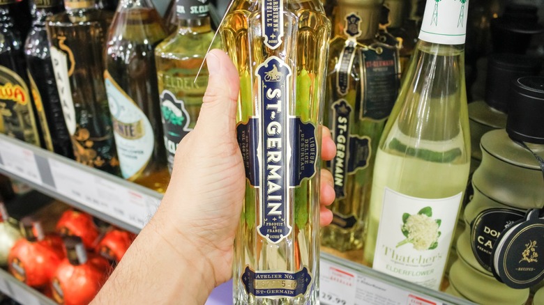 Hand holding a bottle of St-Germain