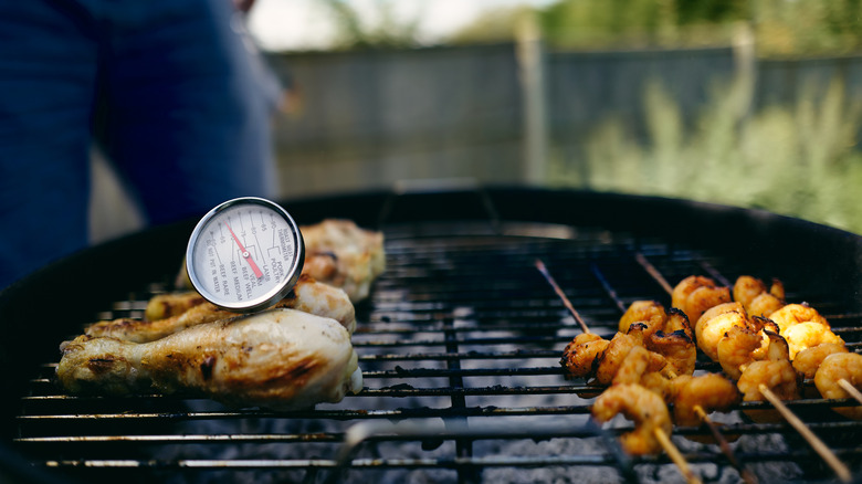 chicken on grill with meat thermometer inserted