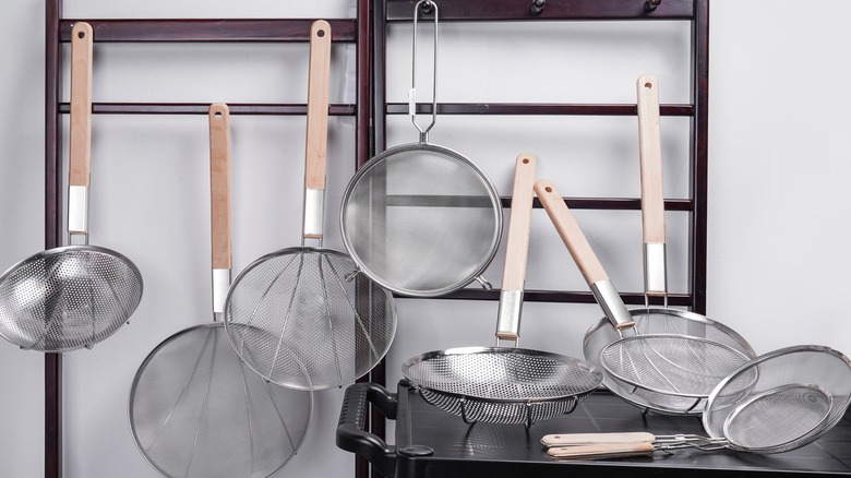 kitchen strainers hanging on a wrack