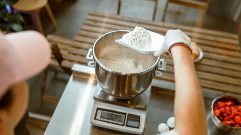 Person measuring flour on a scale