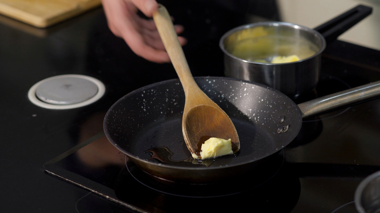 adding butter to a saucepan