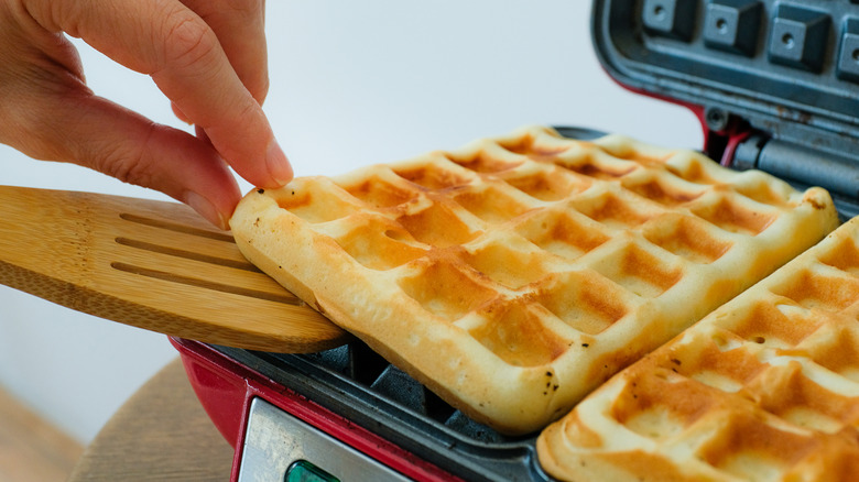 An open waffle iron with a waffle still in it