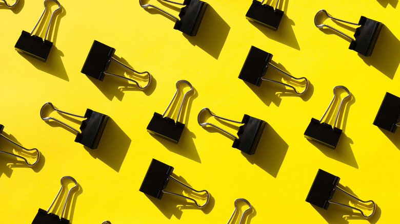 Binder clips against yellow background