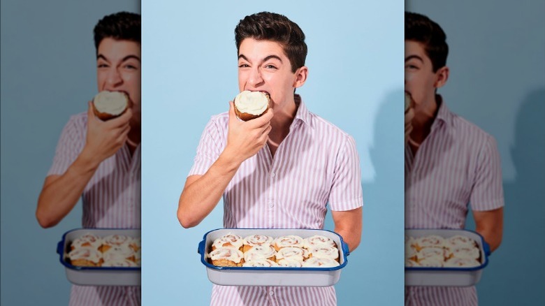 Eitan Bernath holds tray of cinnamon rolls