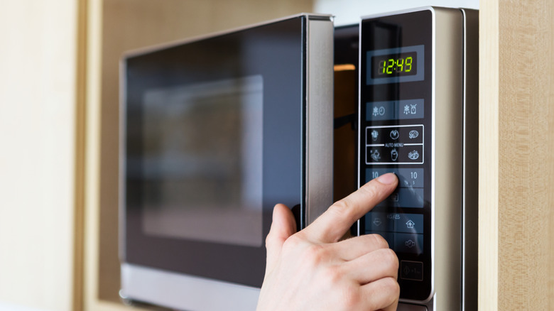 person using microwave