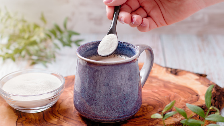 Woman adding collagen to coffee