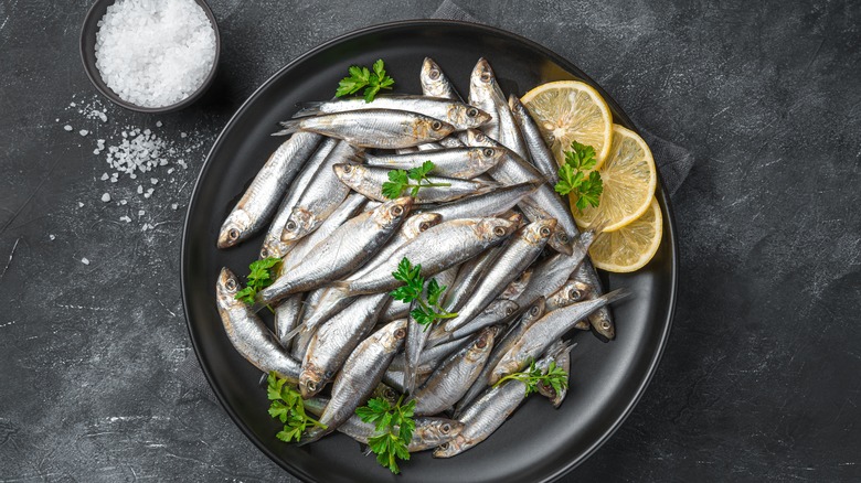 fresh anchovies and lemon slices on plate