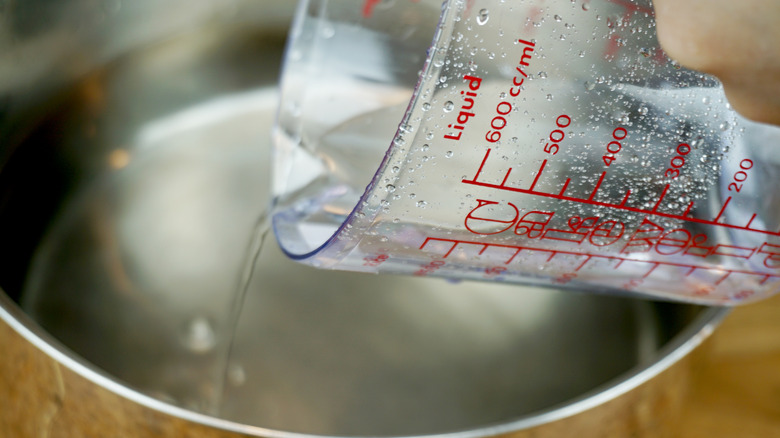 Pouring water from measuring cup