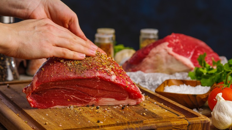 Applying spice rub to meat