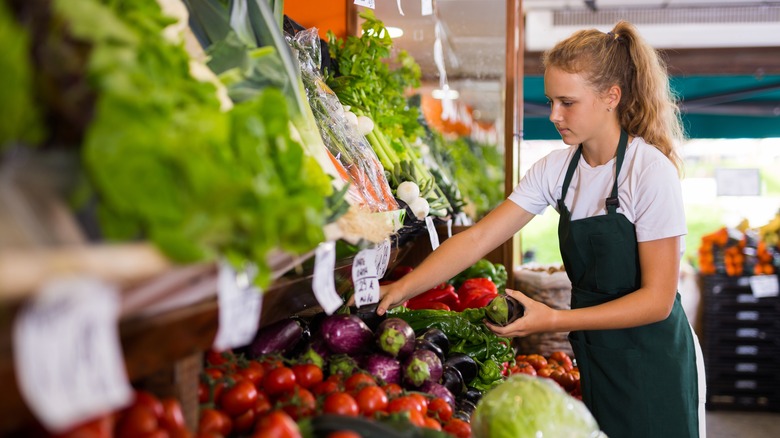 Chef selecting eggplant at market