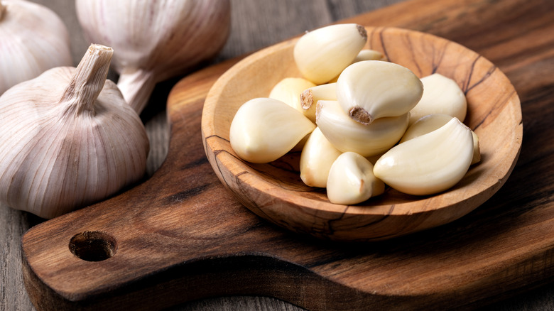 peeled garlic cloves in wooden bowl