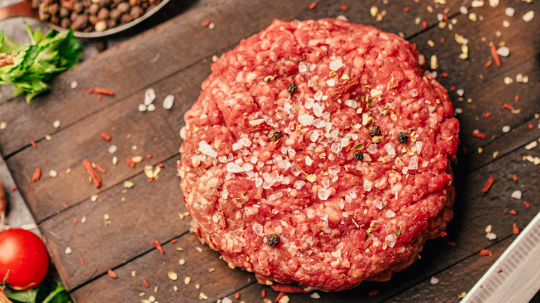 Raw burger patty with seasoning