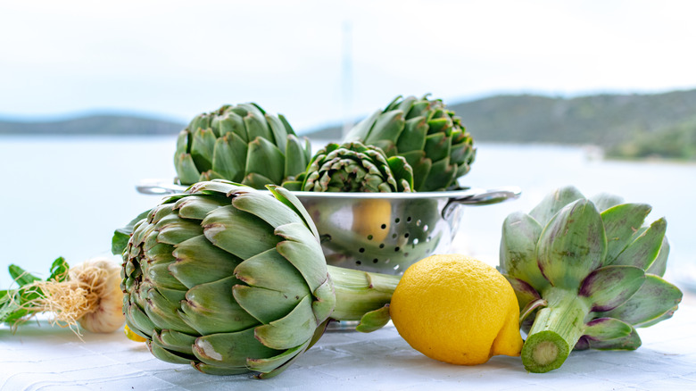 Artichokes in a colander with a lemon