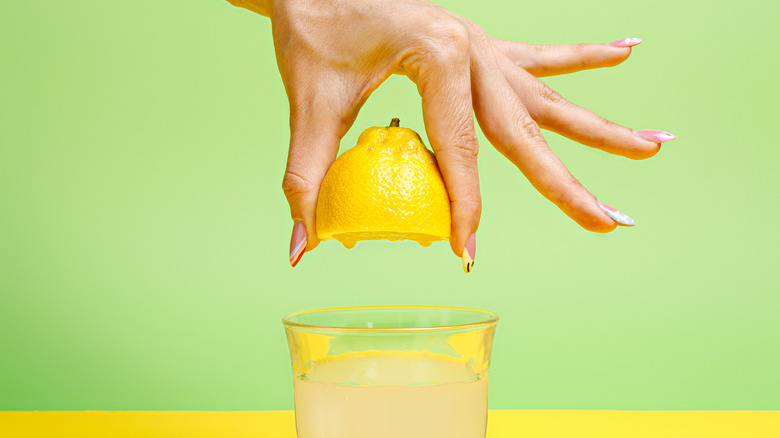 A hand juicing a lemon