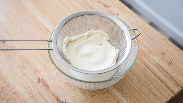 ricotta draining into Pyrex bowl