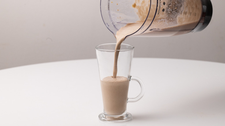 pouring milkshake into a glass