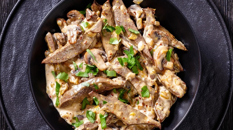 Close-up of tofu and mushroom stroganoff in black plate