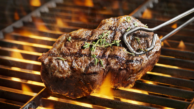 Flipping steak on a grill