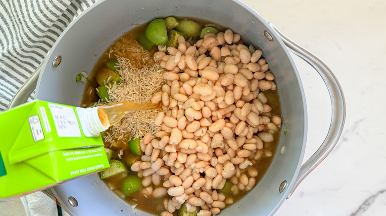 adding broth to pot