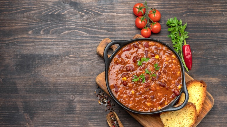 Chili with toast, peppers, and tomatoes