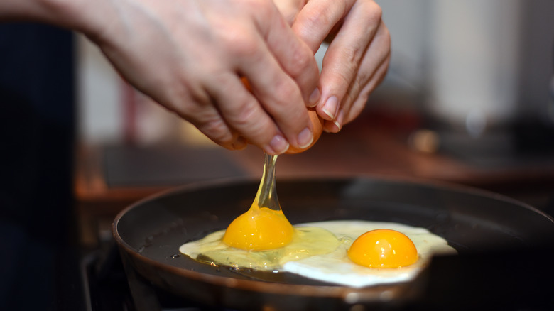 Smashing eggs into a frying pan