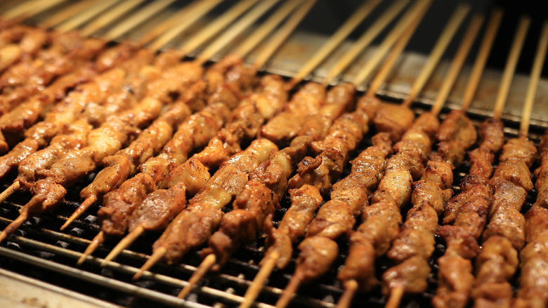 Grilling kebabs over barbecue