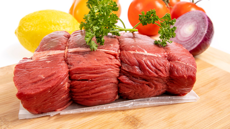 raw sirloin tip roast with whole ingredients and garnish