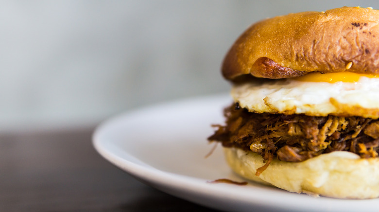 Pulled pork sandwich topped with a fried egg