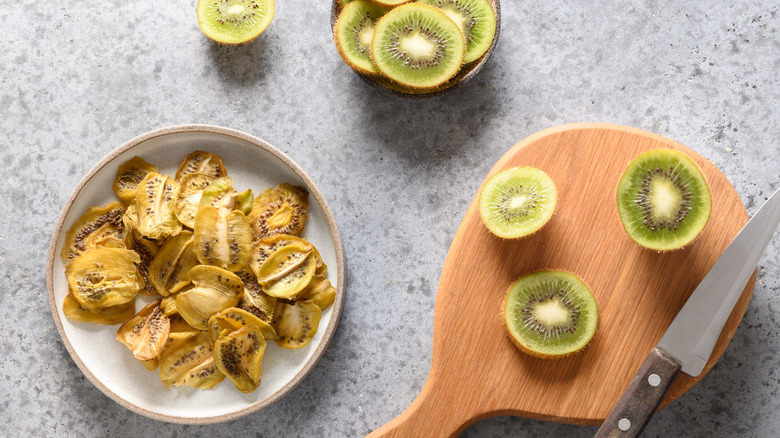 Kiwi chips next to fresh kiwi and knife