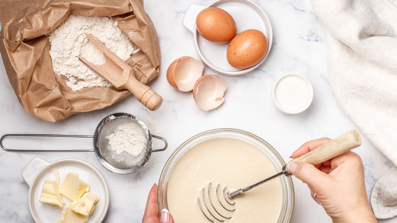 mixing a cake batter in a bowl with ingredients on counter