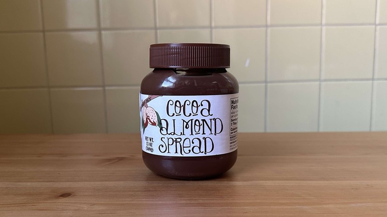 Cocoa Almond Spread on wooden table with yellow tile background