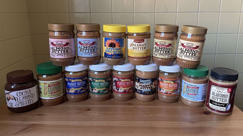 Trader Joe's nut butters on wooden table with yellow tile background