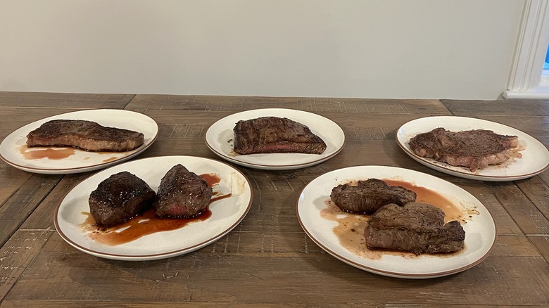 five plates of cooked Trader Joe's steaks on table