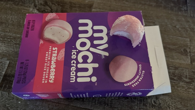 Box of opened strawberry My/Mochi ice cream with one bitten on top of box