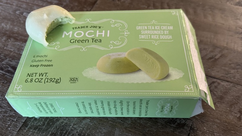 Opened box of Trader Joe's mochi ice cream with a bitten piece on top of the box