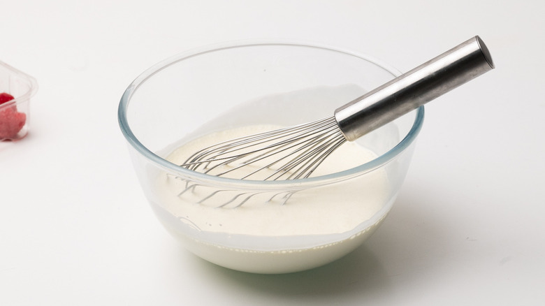 cream in bowl with whisk