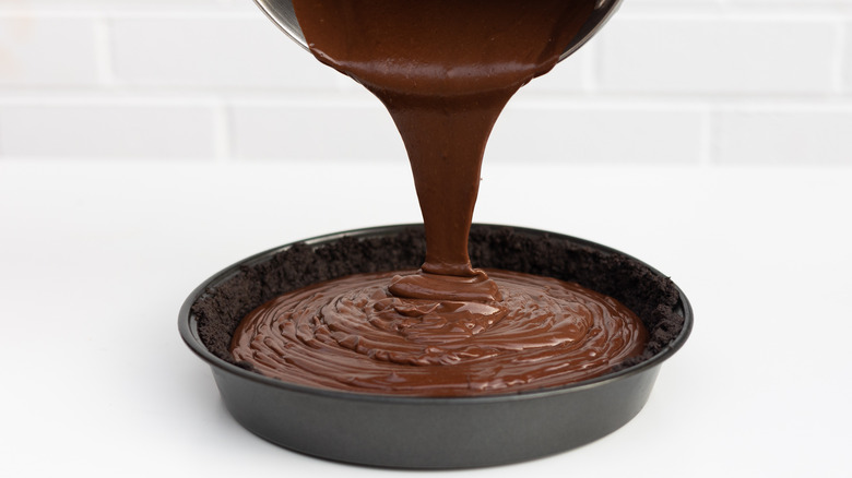 pouring chocolate custard into crust