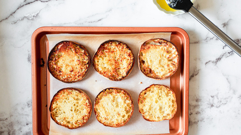 six toasted English muffin halves on baking sheet 