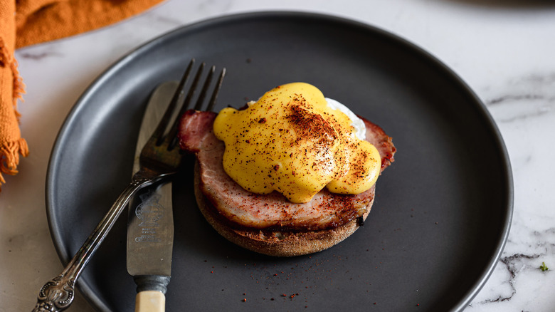 eggs benedict on a black plate