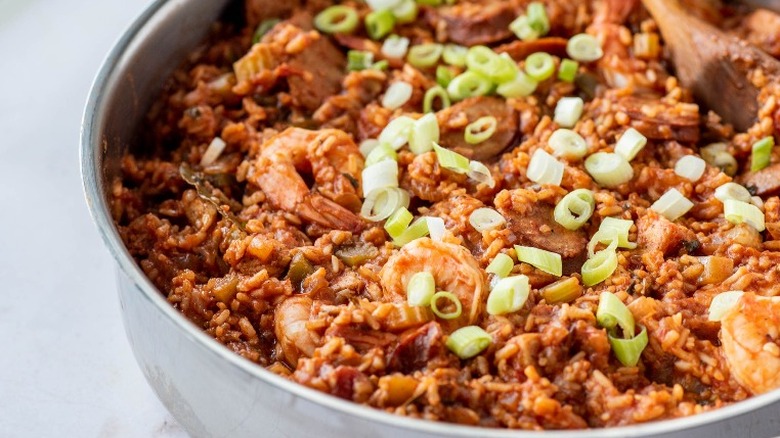 green onion on top of finished jambalaya in a skillet