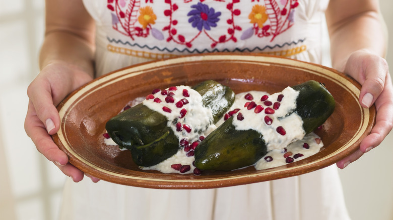 woman serving Chiles en Nogada