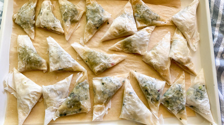 unbaked spanakopita on sheet pan