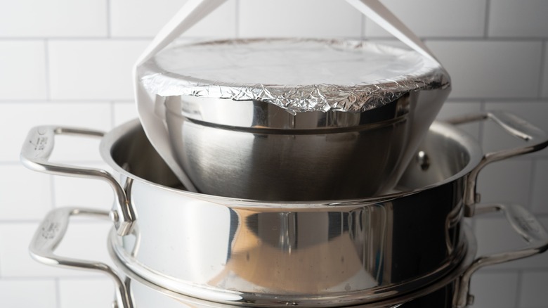 covered bowl lowered into steamer