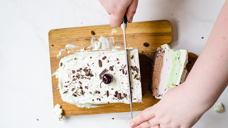 spumoni ice cream on a wooden cutting board being sliced